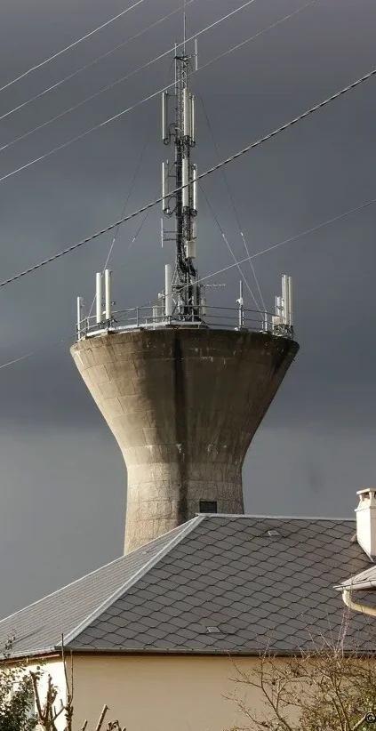 Château d’eau avec antennes-relais GSM, ciel orageux